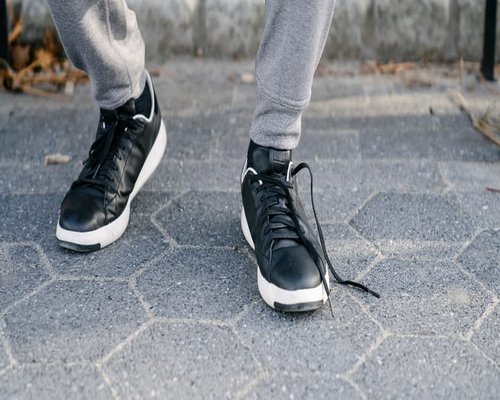 A person wearing comfortable sneakers walking on a city sidewalk